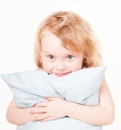 happy little girl hugging pillow