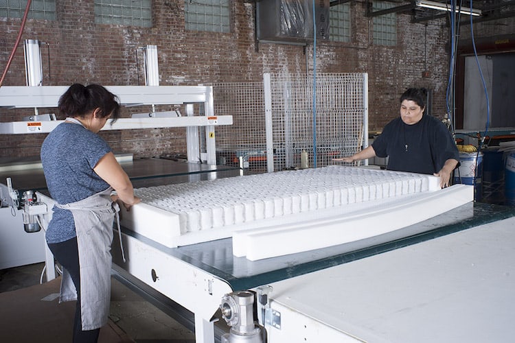 Audelia Fernandez, left, and Ana Sanchez assemble a foam-encased pocket spring mattress.