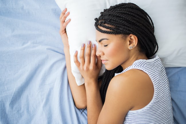 African-American teenage girl sleeping in bed
