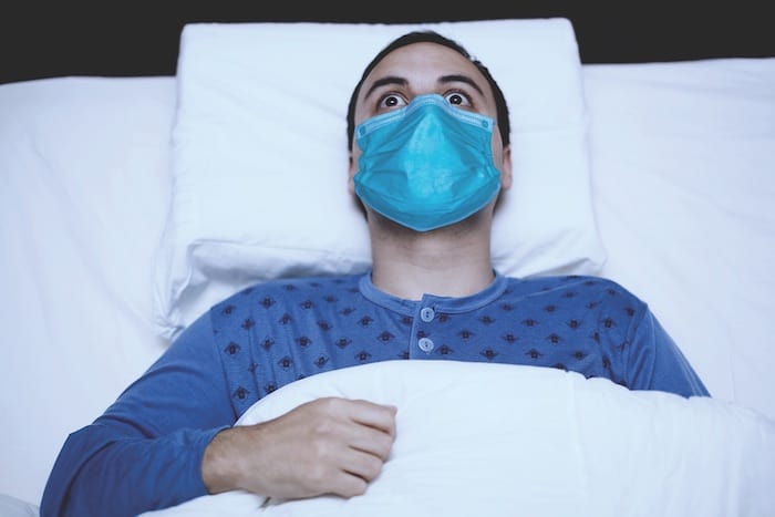 guy in bed wearing mask
