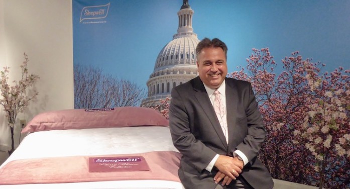Paul Kahl, AW Industries vice president of sales, is pictured with a mattress model from the company’s Cherry Blossom collection, part of its Sleepwell brand. The new Cherry Blossom mattresses feature a Repreve cover from Culp Inc. made of recycled plastic.