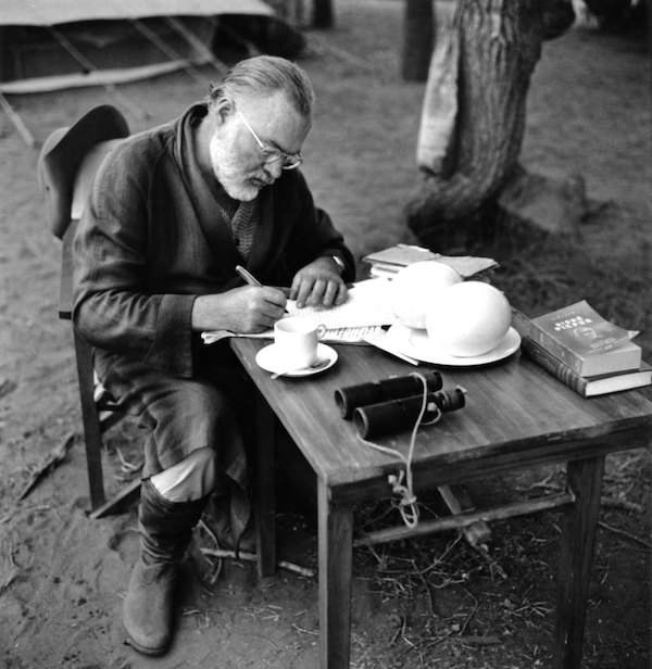 KENYA - SEPTEMBER 1952: Author Ernest Hemingway writes at a portable table while on a big game hunt in September 1952 in Kenya.  (Photo by Earl Theisen/Getty Images)
