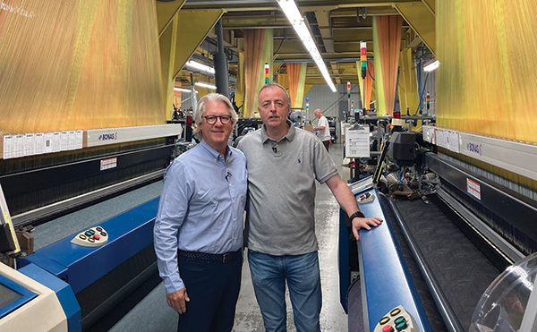 CT Nassau Vice President of Sales Taber Wood, left, and Paolo Stellini, managing director of Stellini Textile Group, give BedTimes magazine a tour of the ticking factory in Burlington, North Carolina, which includes these jacquard looms.