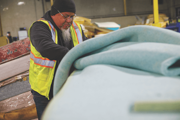 In the United States, the initial stage of mattress dismantling (or “decasing”) is done manually by workers such as these at a recycling facility in Willimantic, Connecticut, owned by Casella Waste Systems Inc.