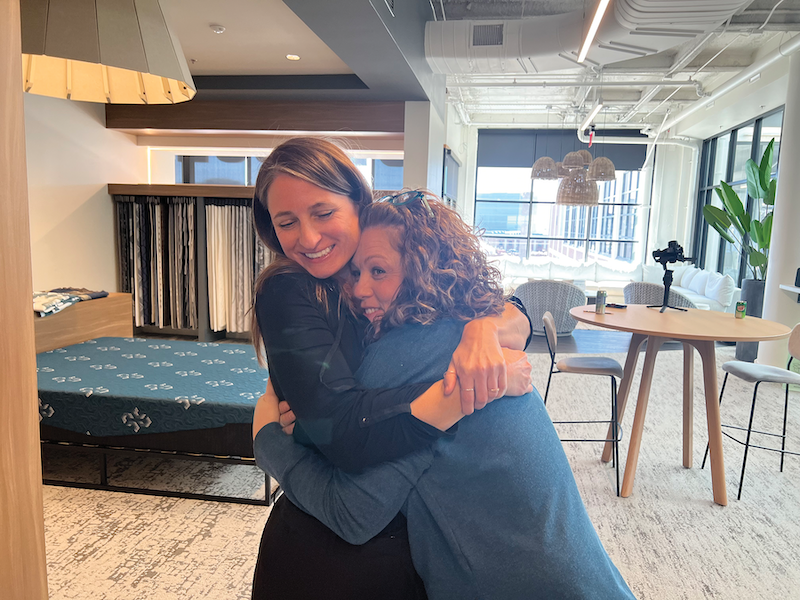 Bulla, right, a Culp designer of 25 years, hugs fellow designer Tusa.
Bulla says the company is so close that it’s like family.