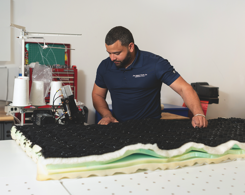 New England Needles technician Lennix Rosa sews a thick, heavy mattress panel on a SttchEx machine.