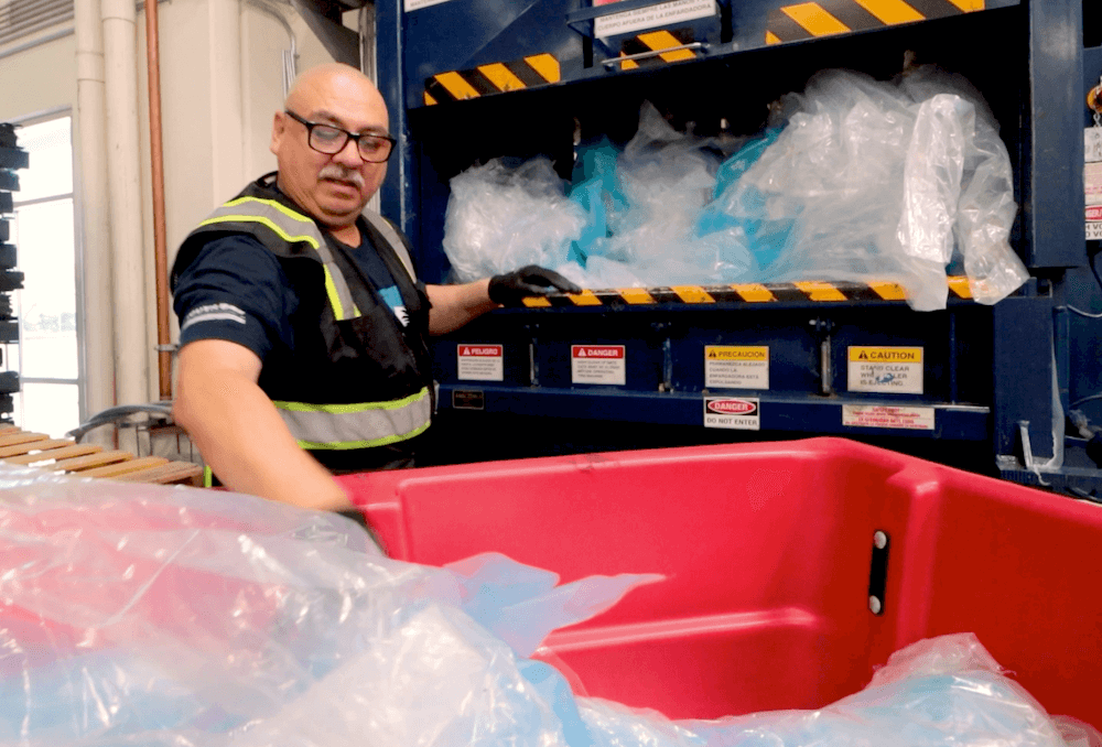 An employee at South Bay International bales leftover plastic from the manufacturing process
 for resale on secondary markets.