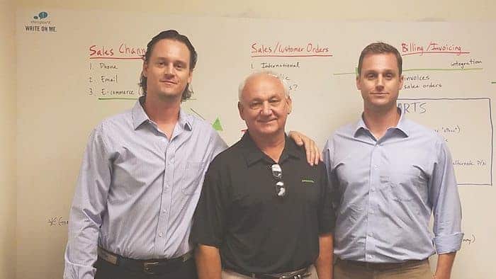 Three Porter family members, owners of Jumpsource, pose in front of whiteboard.